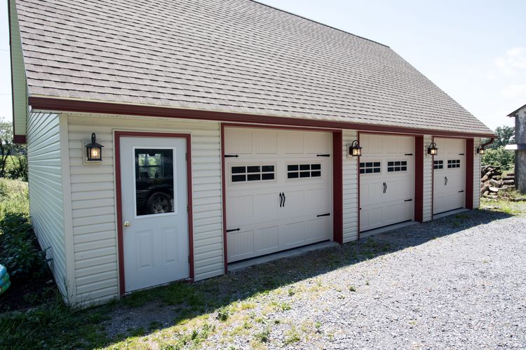 Three white single-car carriage house garage doors on dedicated garate