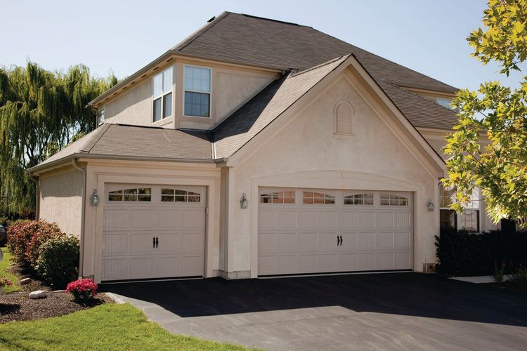 Sandstone carriage house garage doors on white house