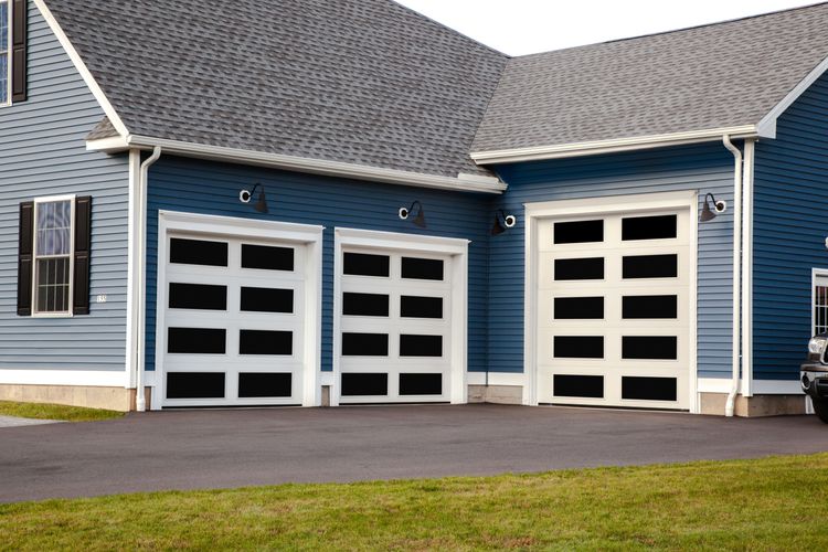 Three adjacent polar white glass garage doors