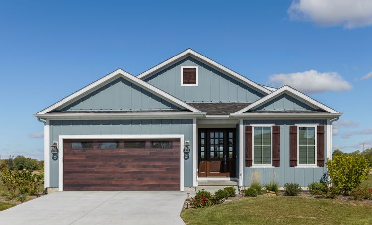 Blue home with modern stained brown planked garage door with windows.